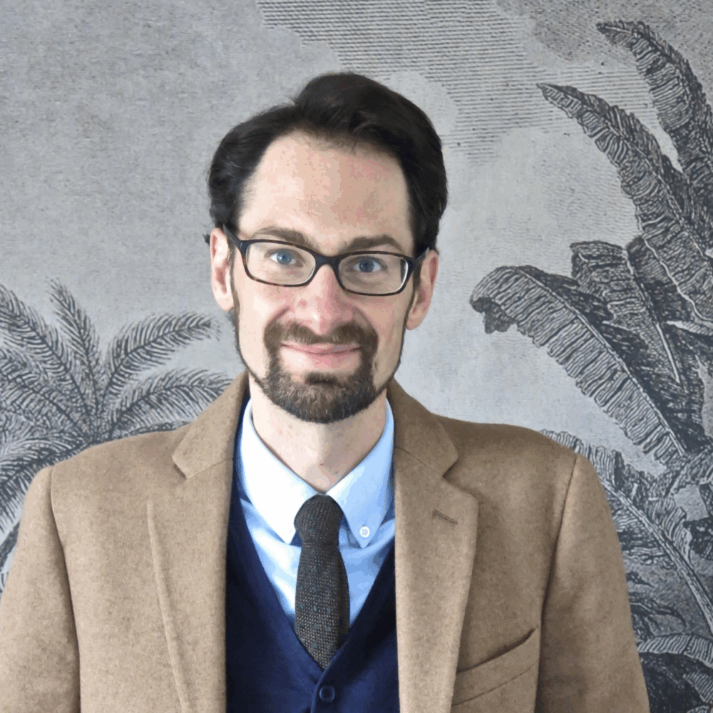 Portrait de face d'un homme appuyé sur un meuble sur lequel est posé un globe-terrestre.