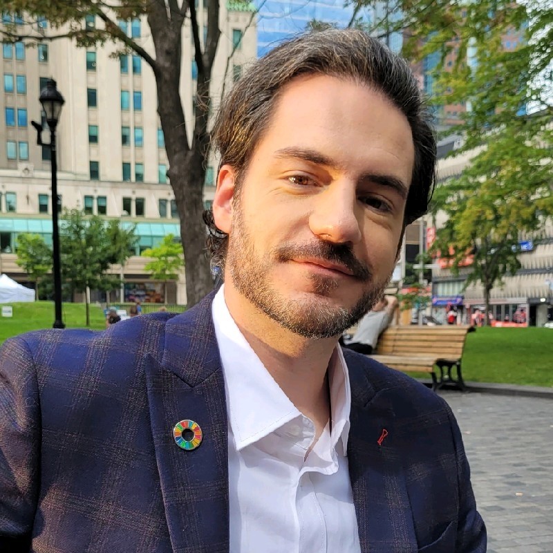 portrait de face d'une personne portant un costume dans un parc