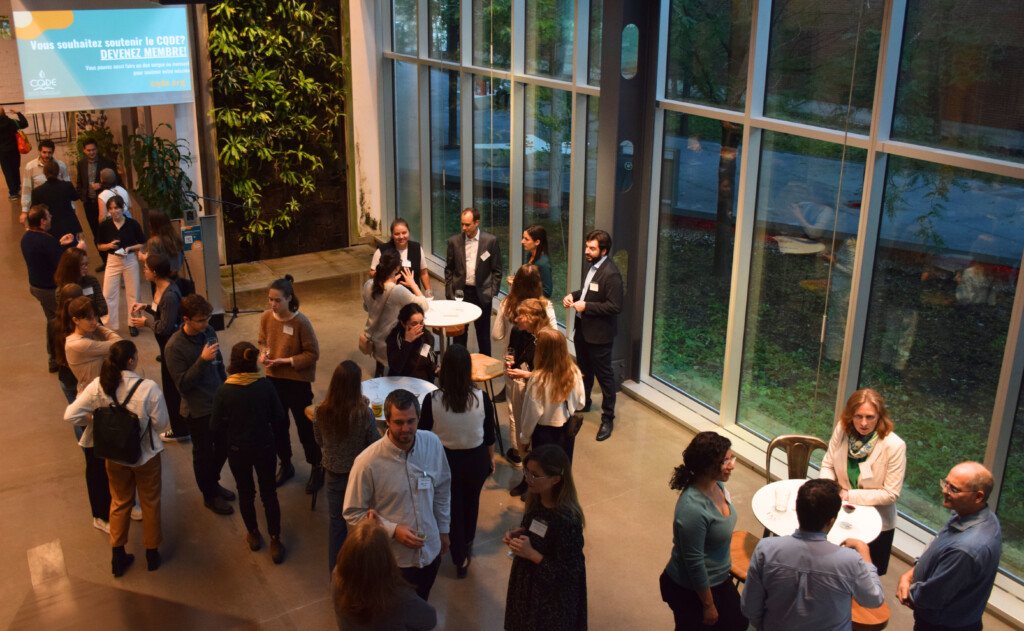 Plusieurs dizaines de personnes debout, discutent entre elles lors d'un événement professionnel.